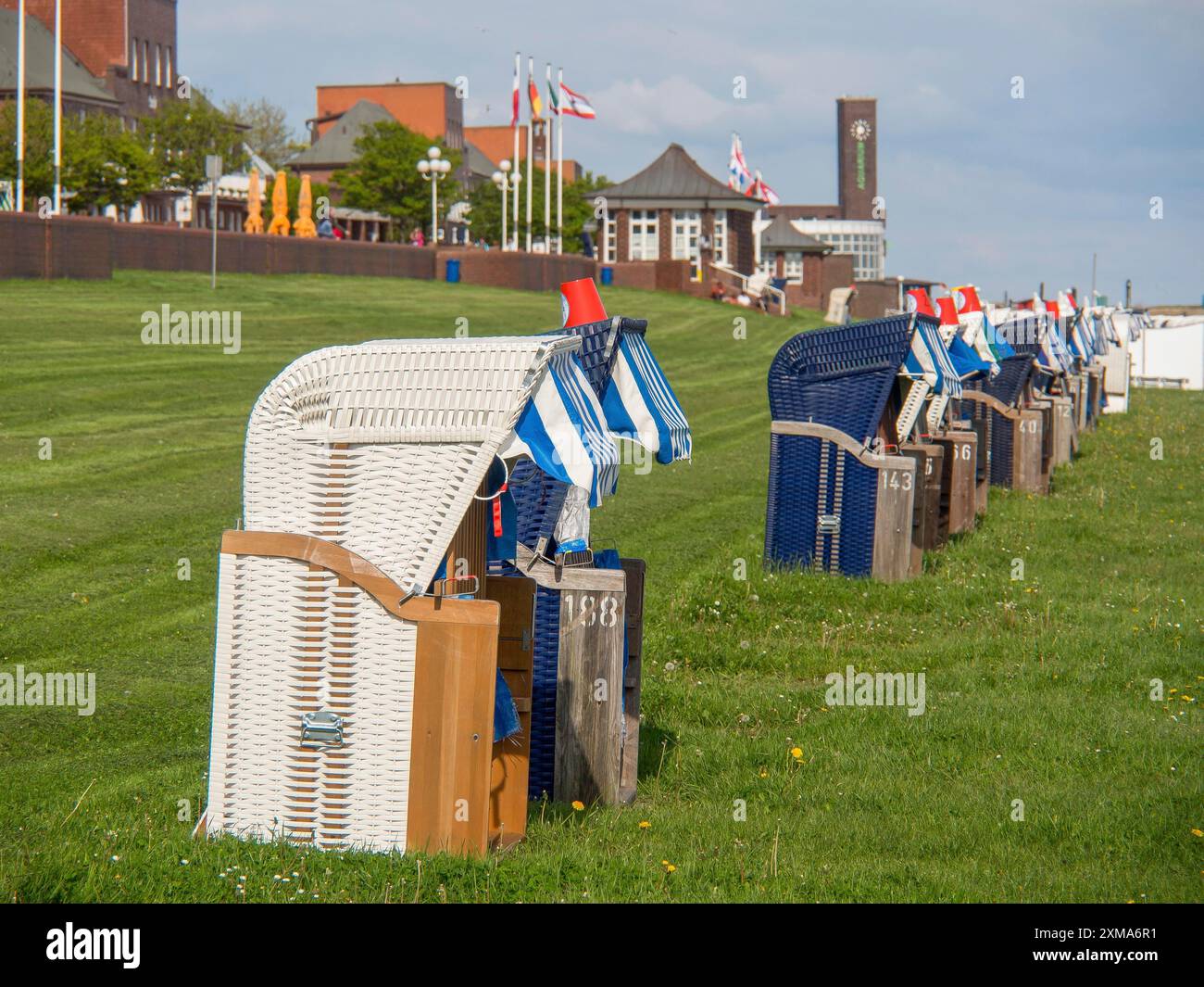 Liegenreihe auf einer Wiese, Gebäude und Fahnen im Hintergrund, wilhelmshaven, deutschland Stockfoto