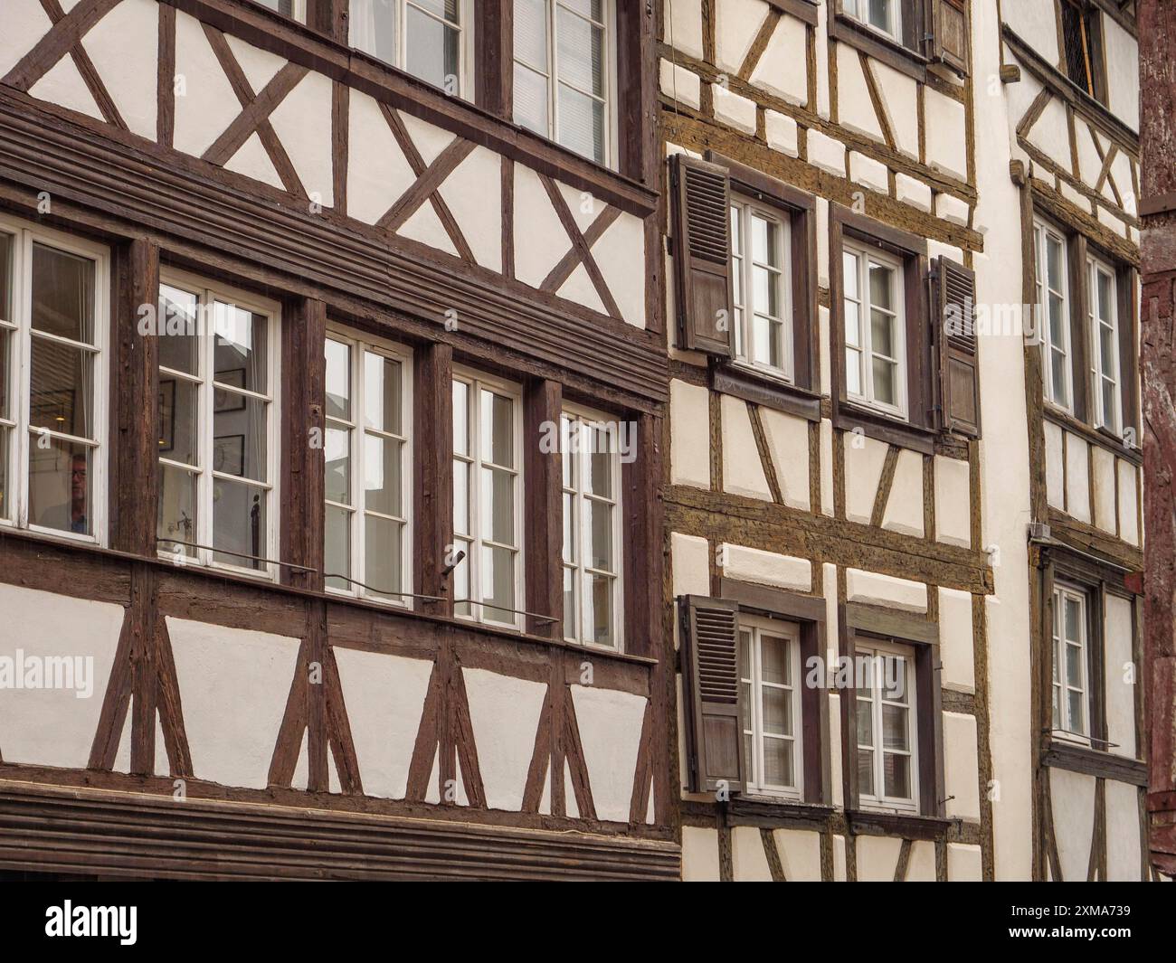 Fachwerkhäuser mit vielen Fenstern an einem regnerischen Tag, die die historische Architektur betonen, straßburg, frankreich Stockfoto