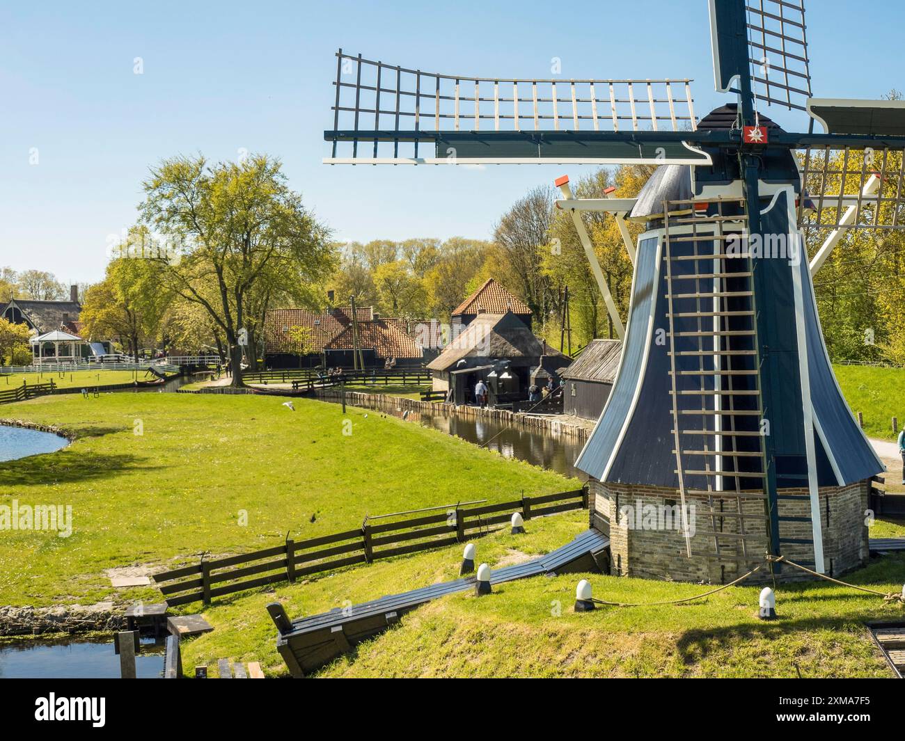 Windmühle neben einem wassergefüllten Graben in grüner, ländlicher Umgebung, enkhuizen, niederlande Stockfoto