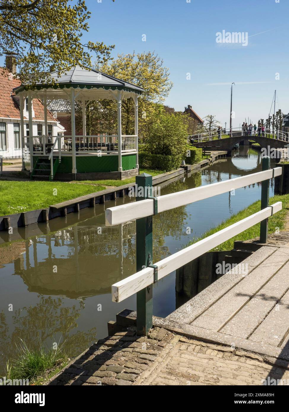 Kleiner Pavillon am Kanal, weiße Brücke und einige Dorfhäuser im Frühjahr, enkhuizen, niederlande Stockfoto