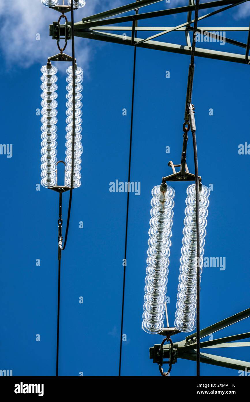 Isolatoren aus Glas an einer Hochspannungsleitung hängen sie als Aufhängevorrichtung zwischen dem Pylon und dem stromführenden, nicht isolierten Kabel an den Pylonen Stockfoto