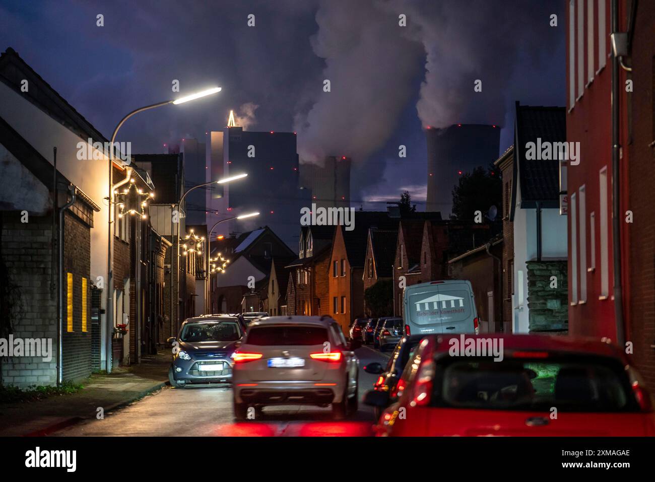 Das Dorf Vanikum, Teil der Gemeinde Rommerskirchen, Hauptstraße, dahinter das Braunkohlekraftwerk Neurath, bei Grevenbroich Stockfoto