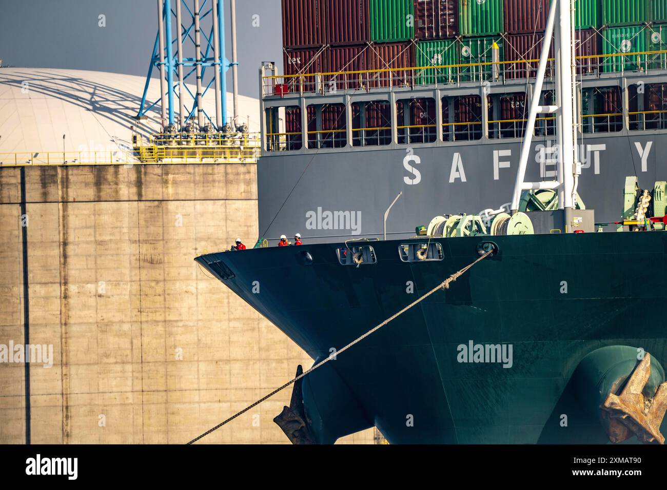 LNG-Import-Terminal-Tanks für Flüssigerdgas im Seehafen Rotterdam bringt Hafenschlepper den Containerfrachter Ever Globe an seinen Liegeplatz Stockfoto