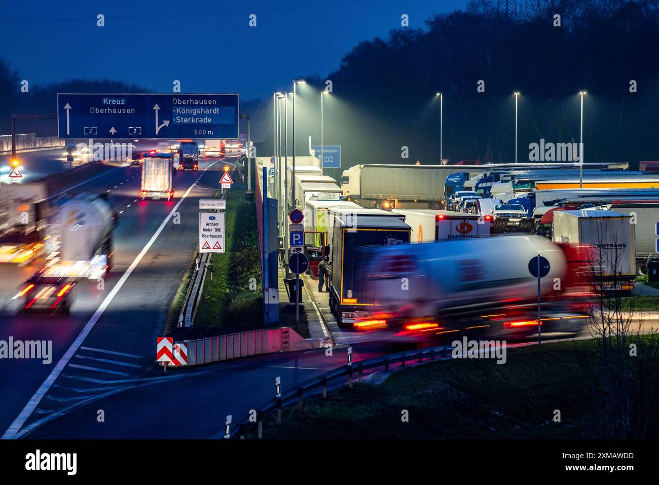 Starker Verkehr auf der A2 an der Raststätte Schwarze Heide, Bottrop, überfüllter Parkplatz für LKW am Abend, Bottrop, Nordrhein-Westfalen Stockfoto