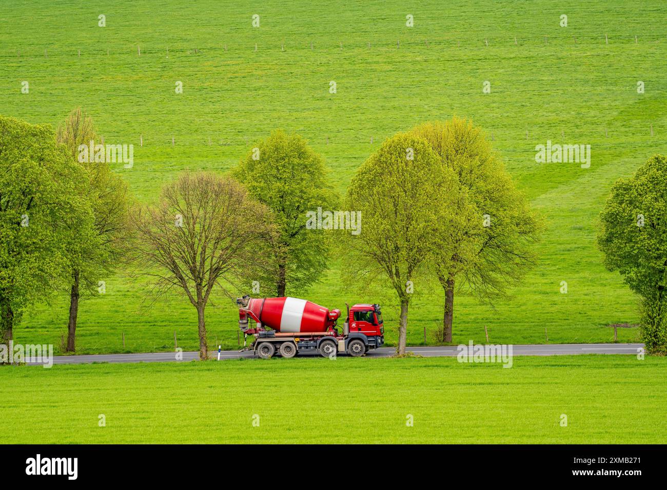 Betonmischwagen auf einer Landstraße, grüne Felder, Wiesen, Bäume säumen die zweispurige Straße, Frühling, bei Schwelm, Nordrhein-Westfalen Stockfoto