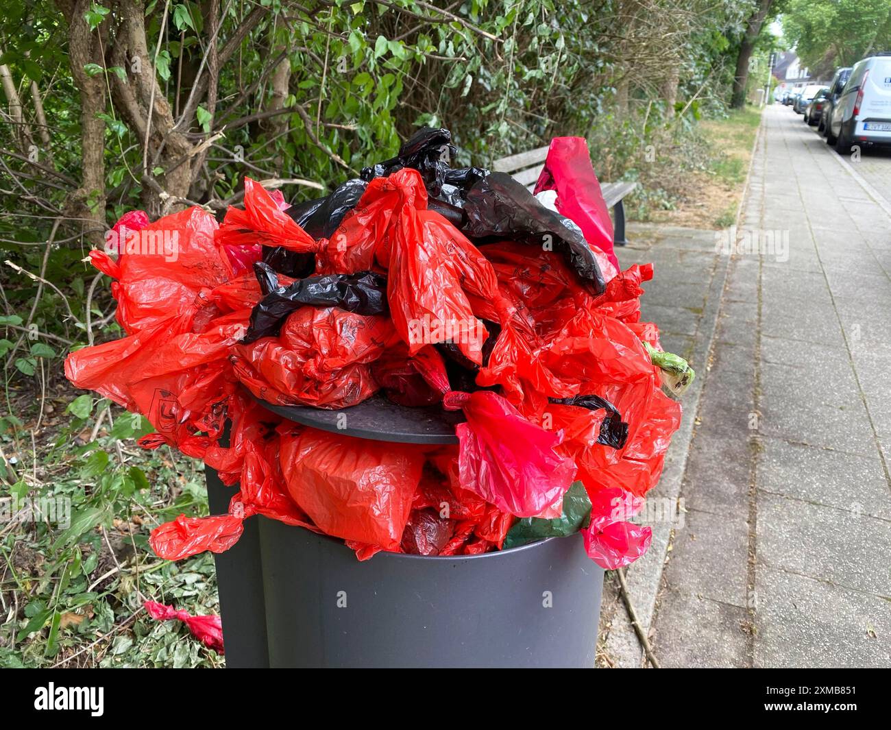 Überlaufender Mülltonne, mit viel Müll, überfüllt mit Hundekot-Taschen, auf einem Mauerweg in Essen, Nordrhein-Westfalen Stockfoto