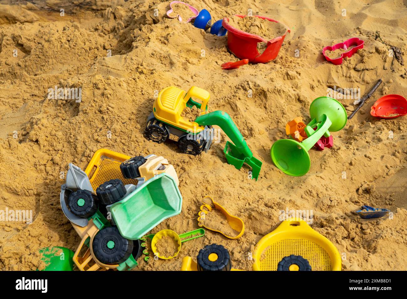 Sandkasten, auf einem Kinderspielplatz, Sandkasten mit verschiedenen Plastikspielzeugen, Bagger, Schaufeln, Formen Sauerland, Nordrhein-Westfalen, Deutschland Stockfoto