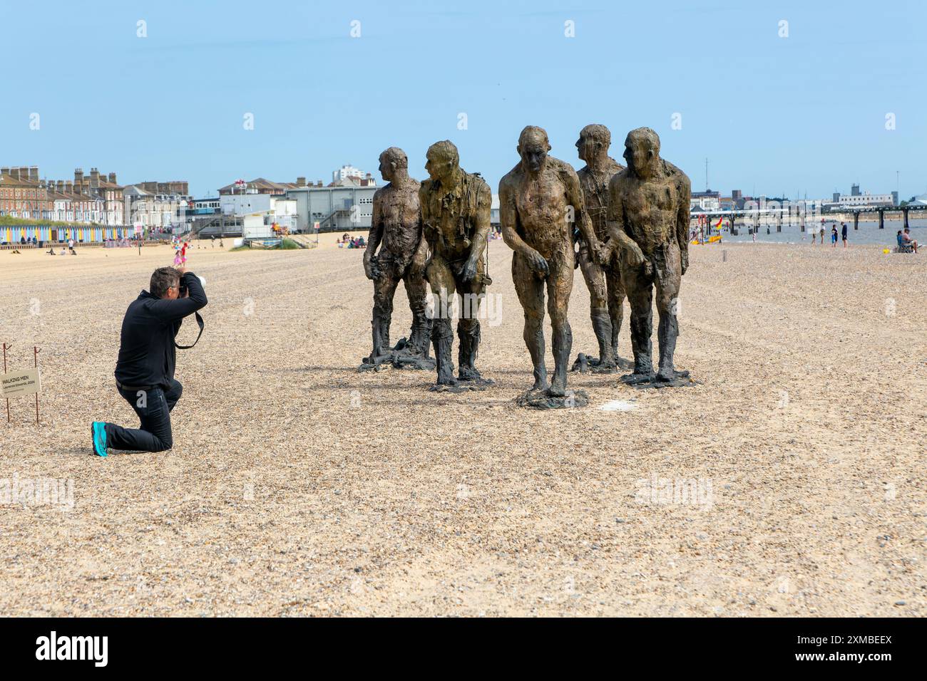 Fotograf „Walking Men“ Kunstwerk Bronzeskulpturen von Laurence Edwards, South Beach, Lowestoft, Suffolk, England, Juli 2024 Stockfoto