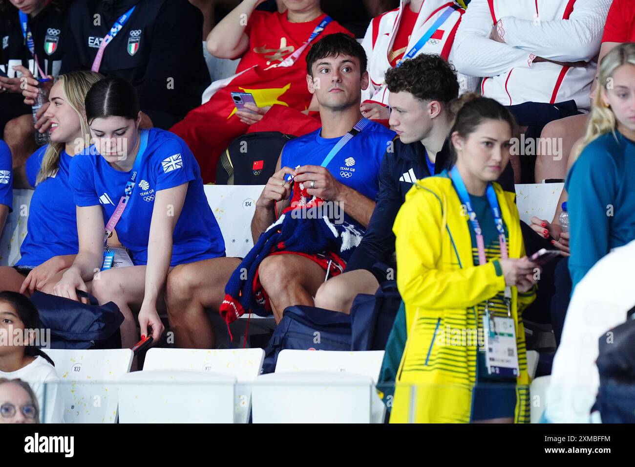 Der britische Tom Daley strickt, während er am ersten Tag der Olympischen Spiele in Paris 2024 in Frankreich das 3-m-Springboard-Finale der Frauen im Aquatics Centre ansieht. Bilddatum: Samstag, 27. Juli 2024. Stockfoto