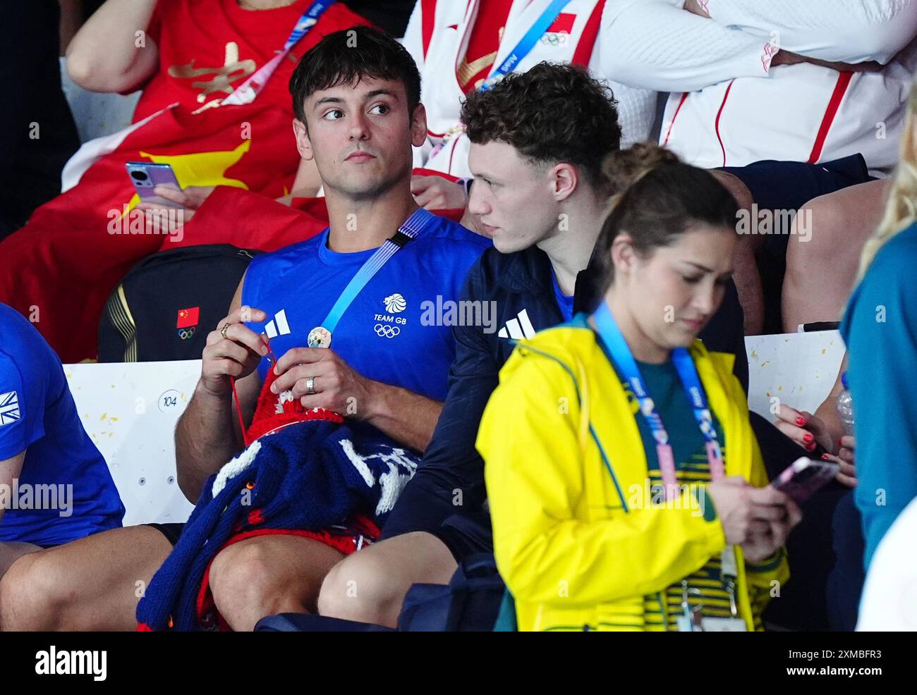 Der britische Tom Daley strickt, während er am ersten Tag der Olympischen Spiele in Paris 2024 in Frankreich das 3-m-Springboard-Finale der Frauen im Aquatics Centre ansieht. Bilddatum: Samstag, 27. Juli 2024. Stockfoto