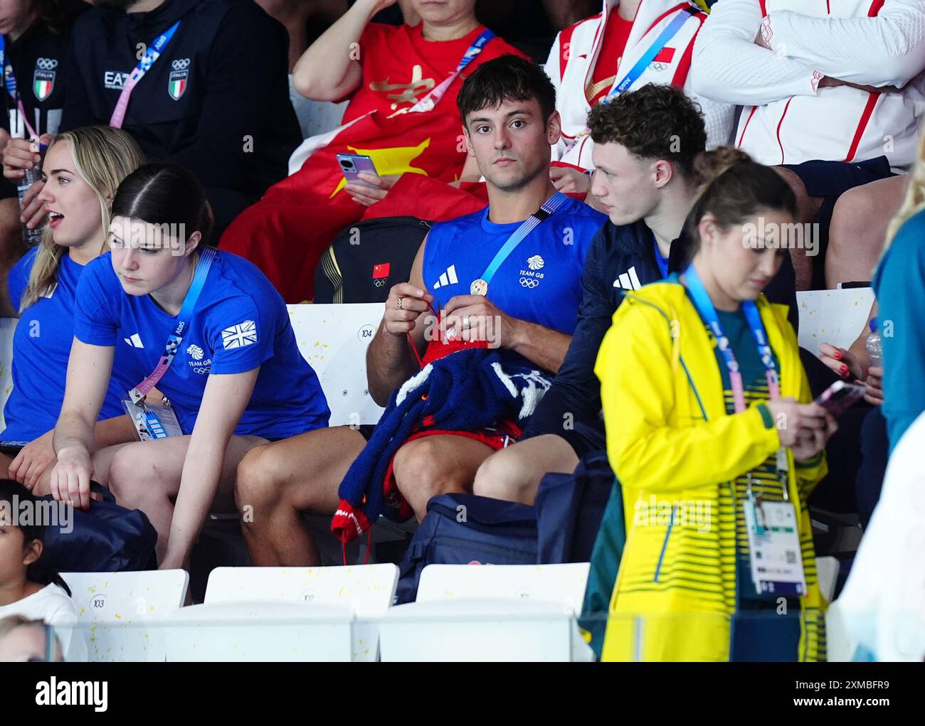 Der britische Tom Daley strickt, während er am ersten Tag der Olympischen Spiele in Paris 2024 in Frankreich das 3-m-Springboard-Finale der Frauen im Aquatics Centre ansieht. Bilddatum: Samstag, 27. Juli 2024. Stockfoto