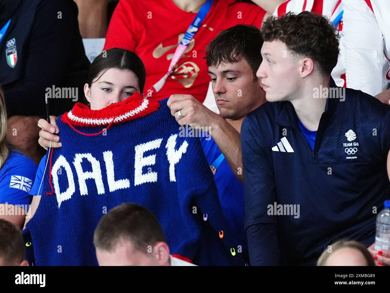 Der britische Tom Daley strickt, während er am ersten Tag der Olympischen Spiele in Paris 2024 in Frankreich das 3-m-Springboard-Finale der Frauen im Aquatics Centre ansieht. Bilddatum: Samstag, 27. Juli 2024. Stockfoto