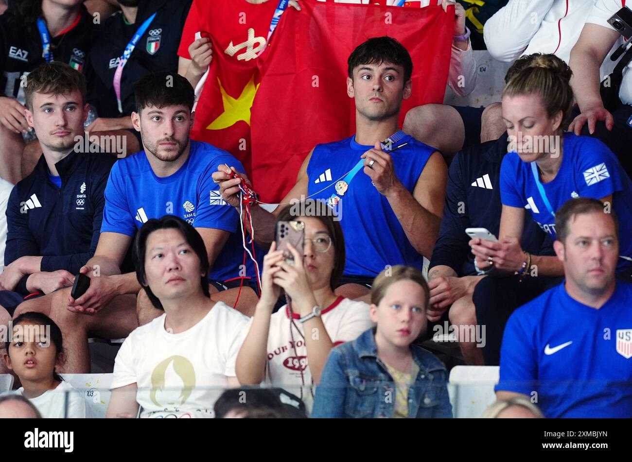 Der britische Tom Daley strickt, während er am ersten Tag der Olympischen Spiele in Paris 2024 in Frankreich das 3-m-Springboard-Finale der Frauen im Aquatics Centre ansieht. Bilddatum: Samstag, 27. Juli 2024. Stockfoto