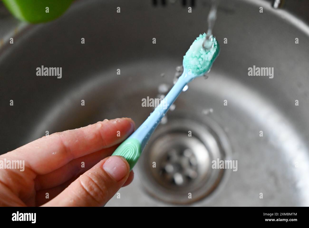 Wassertropfen fallen auf eine Zahnbürste Stockfoto