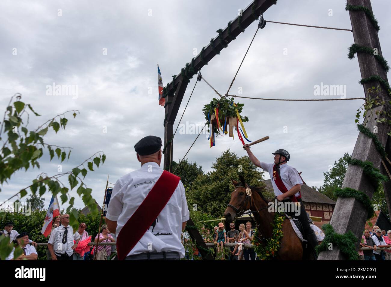 Klockenhagen, Deutschland. Juli 2024. Ein Reiter schlägt eine Heringsboje mit einem Schläger. Er konkurriert mit 15 weiteren Fahrern um mehrere Königstitel beim traditionellen Fassschlagen in Klockenhagen. 2017 wurde die weit verbreitete Praxis des Fass-Schlagens auf der Ostsee in die Liste des immateriellen Kulturerbes der UNESCO aufgenommen. Quelle: Stephan Schulz/dpa/Alamy Live News Stockfoto