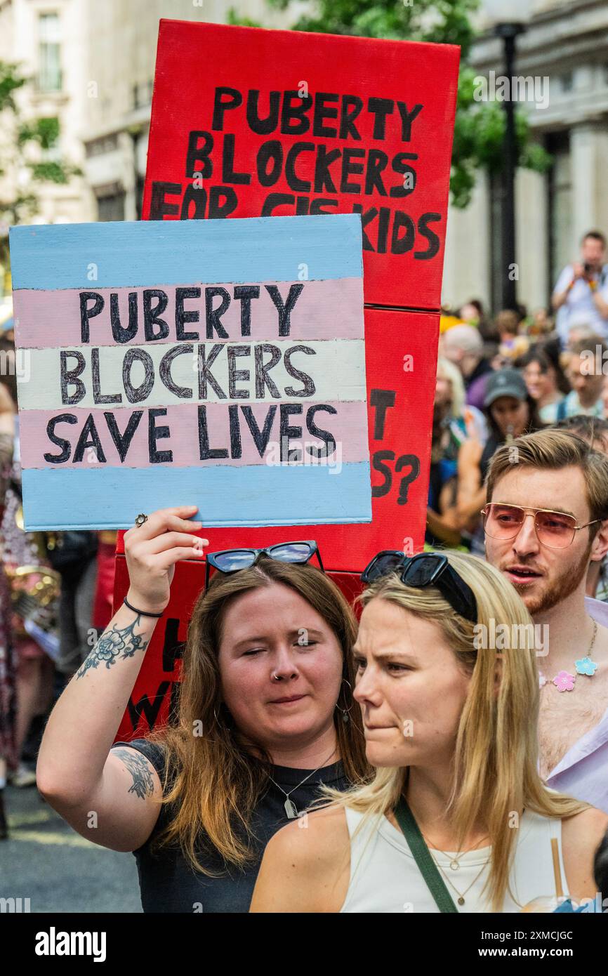 London, Großbritannien. Juli 2024. Unterstützung für Publizitätsblocker auf vielen Plakaten - Trans Pride march in London - „keiner von uns ist frei, bis wir alle frei sind“, protestiert der Satz für dieses Jahr. Sie beginnt am Langham Place in der Nähe des Oxford Circus und endet am Wellington Arch (Hyde Park Corner). Der marsch steht vor dem Hintergrund einer "wachsenden Anti-Trans-Feindseligkeit", der Ermordung der Trans-Teenagerin Brianna Ghey, eines Aufschwungs in der öffentlichen "Debatte" über das Leben von Transgender-Individuen, die Fortsetzung der Reihe zwischen J.K. Rowling und einigen der Stars der Harry Potter-Filme und die Ergebnisse des Cass-Berichts. Gutschrift: Stockfoto