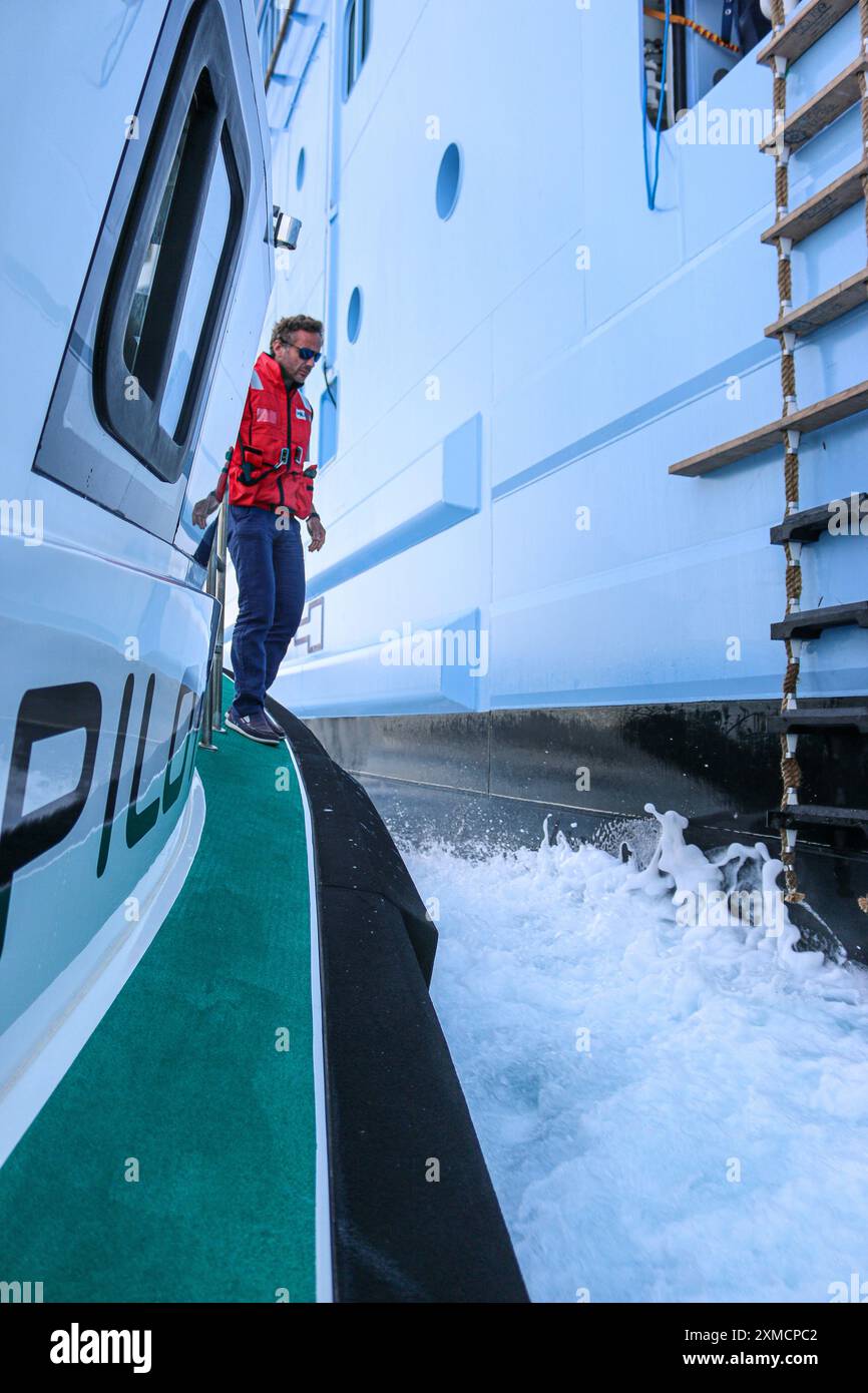 Nizza, Frankreich: Hafenpilotenboot nähert sich der riesigen MEERESHYMNE der Royal Caribbean, um den Seefahrer in Villefranche sur Mer zu besteigen. Ein einzigartiger Zwischenstopp für das größte Kreuzfahrtschiff dieses Jahr im kleinen Hafen der französischen Riviera. Nach der Sommersaison sollte das beeindruckende Schiff im Rahmen einer Umschichtung von Europa nach Singapur durch den Suez-Kanal segeln, aber nach Spannungen am Roten Meer und Drohungen mit Houthi-Raketen auf Schiffe, stattdessen wird sie ohne Passagier die Südspitze Afrikas erkunden, um Dubai und Asien zu erreichen. Quelle: Kevin Izorce/Alamy Live News Stockfoto