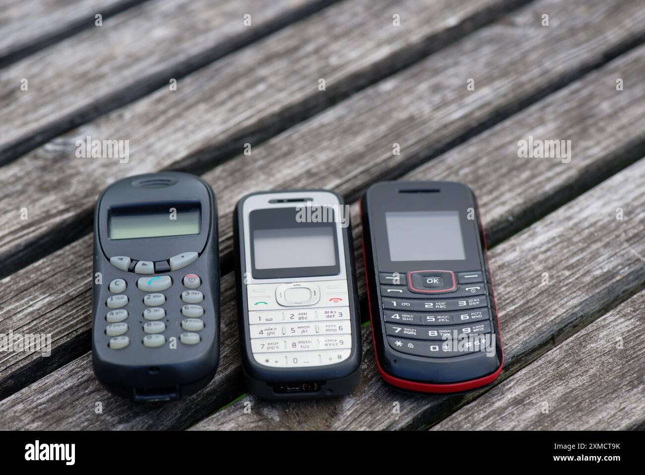 Veraltete Handys auf einem alten verwitterten Holztisch Stockfoto