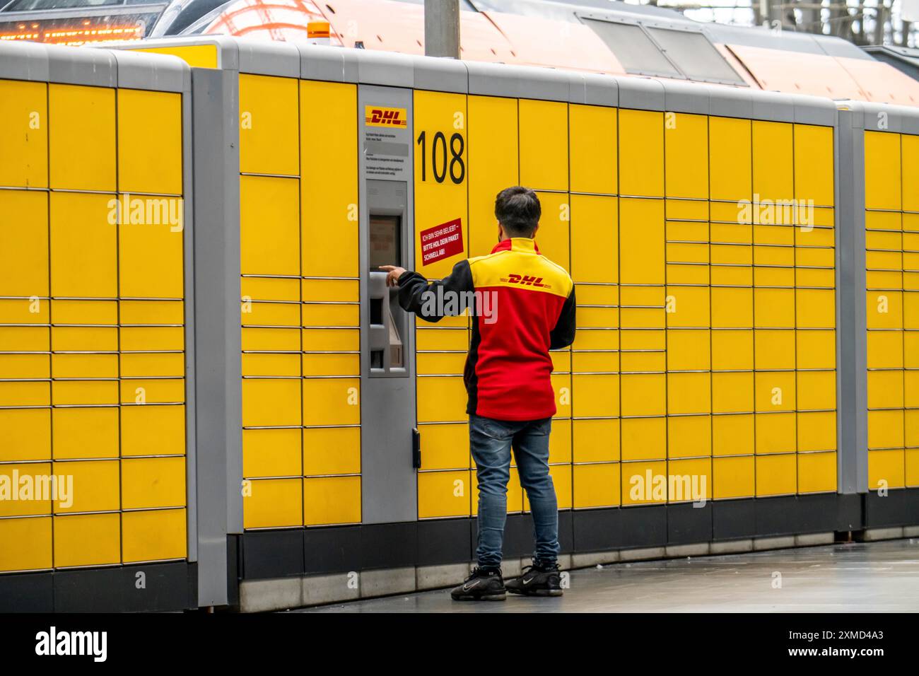 DHL-Paketstation, DHL-Mitarbeiter, der die Paketabholungs- und -Versandstation betreibt, Frankfurt am Main, Hessen, Deutschland Stockfoto