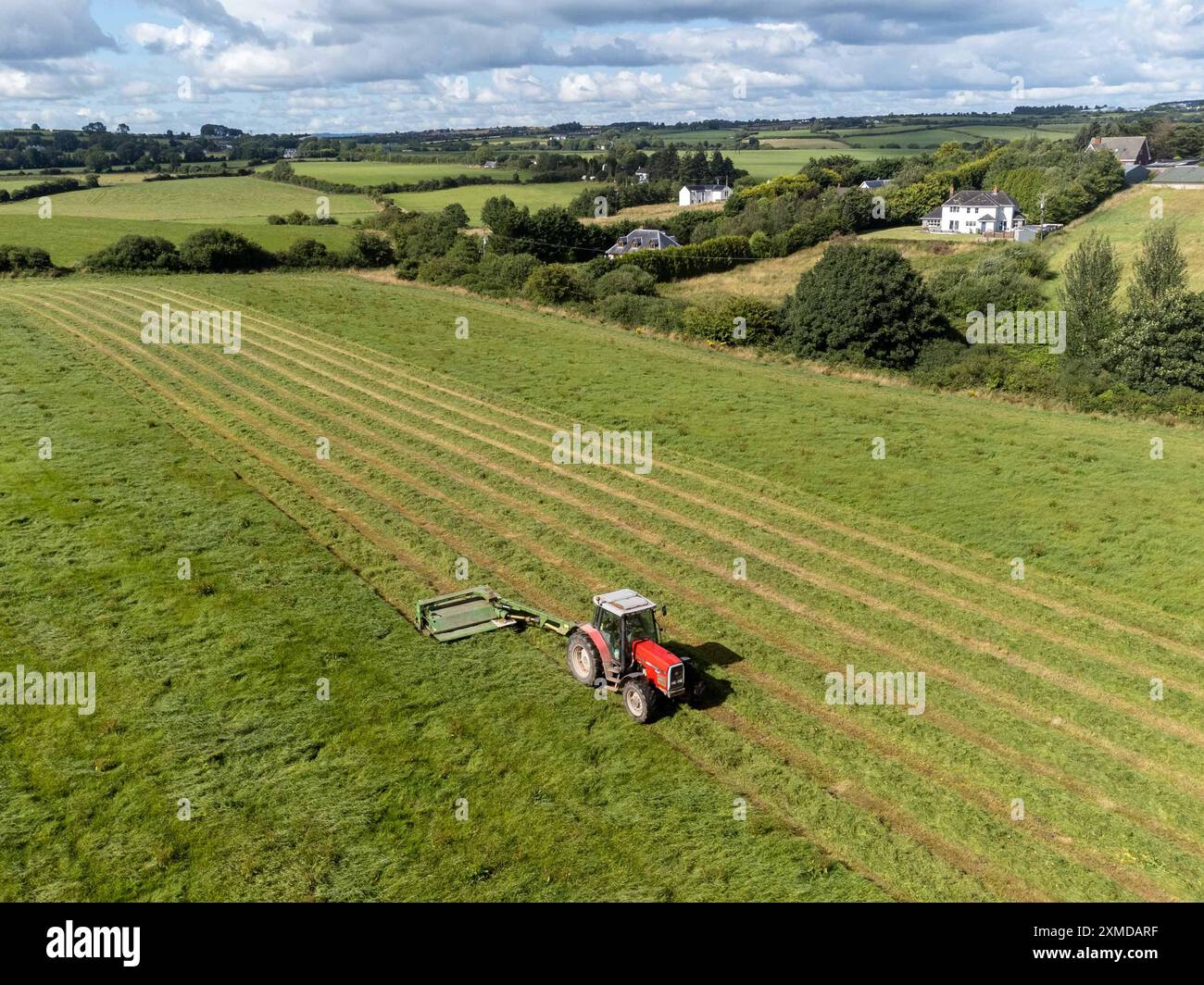 Cork, Irland. Juli 2024. DC 27-7-24 Landwirte nutzen das gute Wetter am Wochenende, Cork, Irland. Mit der Wettervorhersage für die kommende Woche nutzen Landwirte im ganzen Land die Gelegenheit, ihre Arbeit zu erledigen. Auf dem Bild ist ein Bauer in Killcully, Kork schneidet seine Silage. Viele Bauern arbeiten die Nacht durch, während das Wetter gut bleibt, um sicherzustellen, dass sie alle Silage schneiden und sammeln. Quelle: Damian Coleman/Alamy Live News Stockfoto