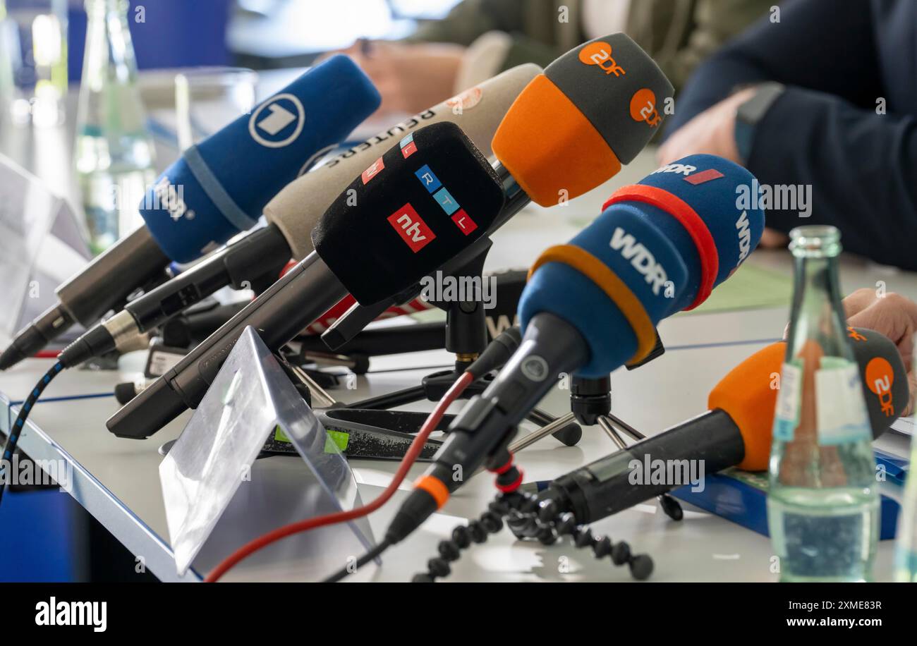 Mikrofone verschiedener Radio- und Fernsehsender stehen bei einer Pressekonferenz auf dem Tisch Stockfoto