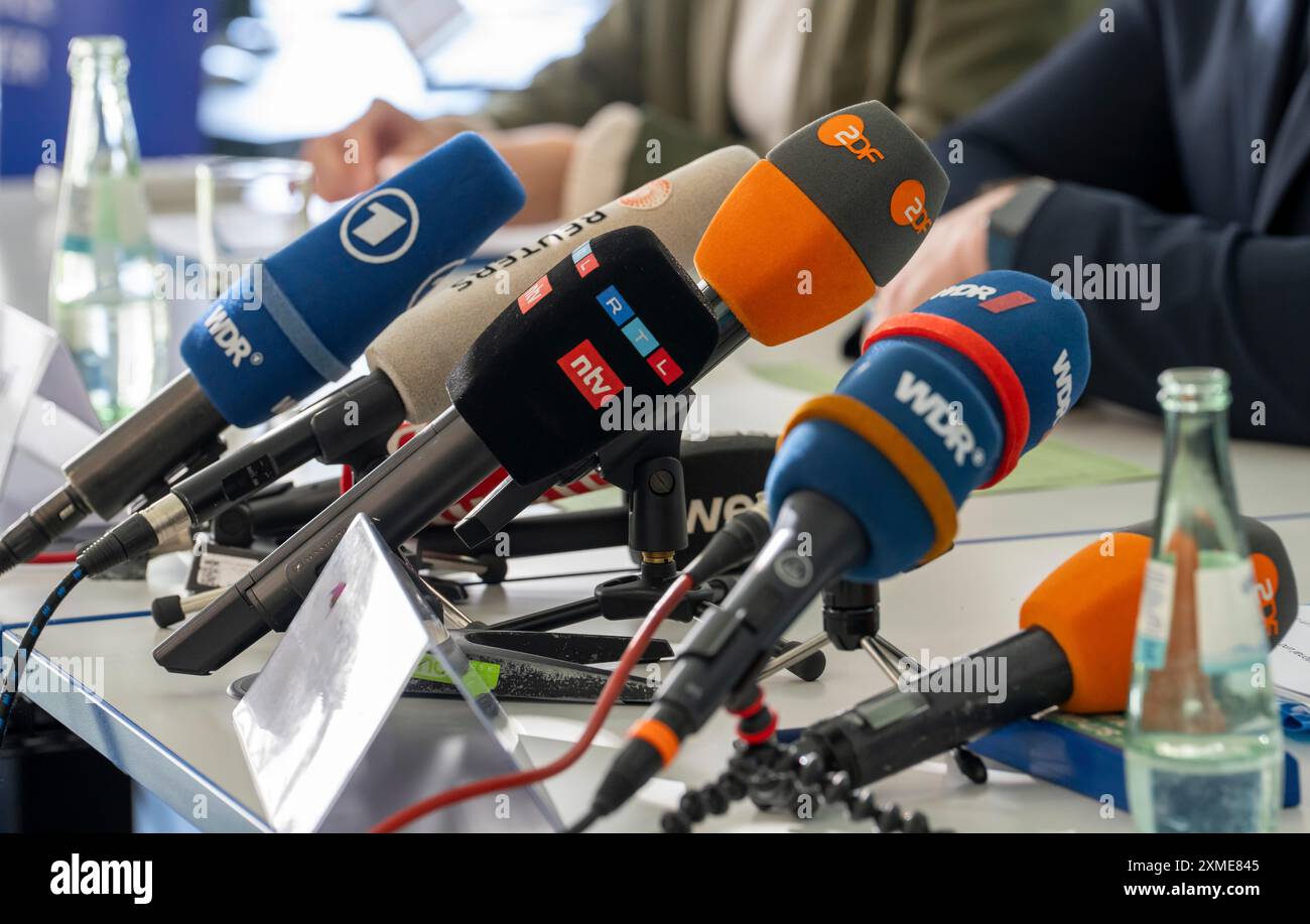 Mikrofone verschiedener Radio- und Fernsehsender stehen bei einer Pressekonferenz auf dem Tisch Stockfoto