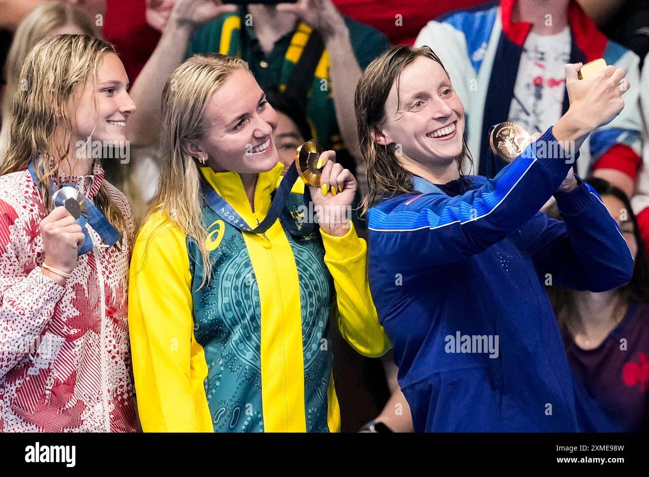 Gold medalist, Ariarne Titmus, of Australia, stands with silver medalist, Summer McIntosh, of Canada, left, and bronze medalist Katie Ledecky, of the United States, right, after the women's 400-meter freestyle final at the 2024 Summer Olympics, Saturday, July 27, 2024, in Nanterre, France. (AP Photo/Martin Meissner) Stockfoto