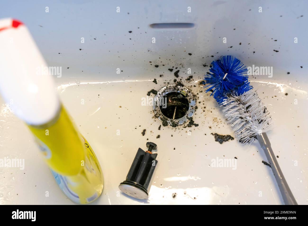 Reinigung von Waschbecken, Handwaschbecken, Badezimmer, mit Hilfe einer längeren Bürste werden Schmutz, Ablagerungen, Schimmel, die sich im Laufe der Zeit ansammeln, entfernt, Reinigung Stockfoto