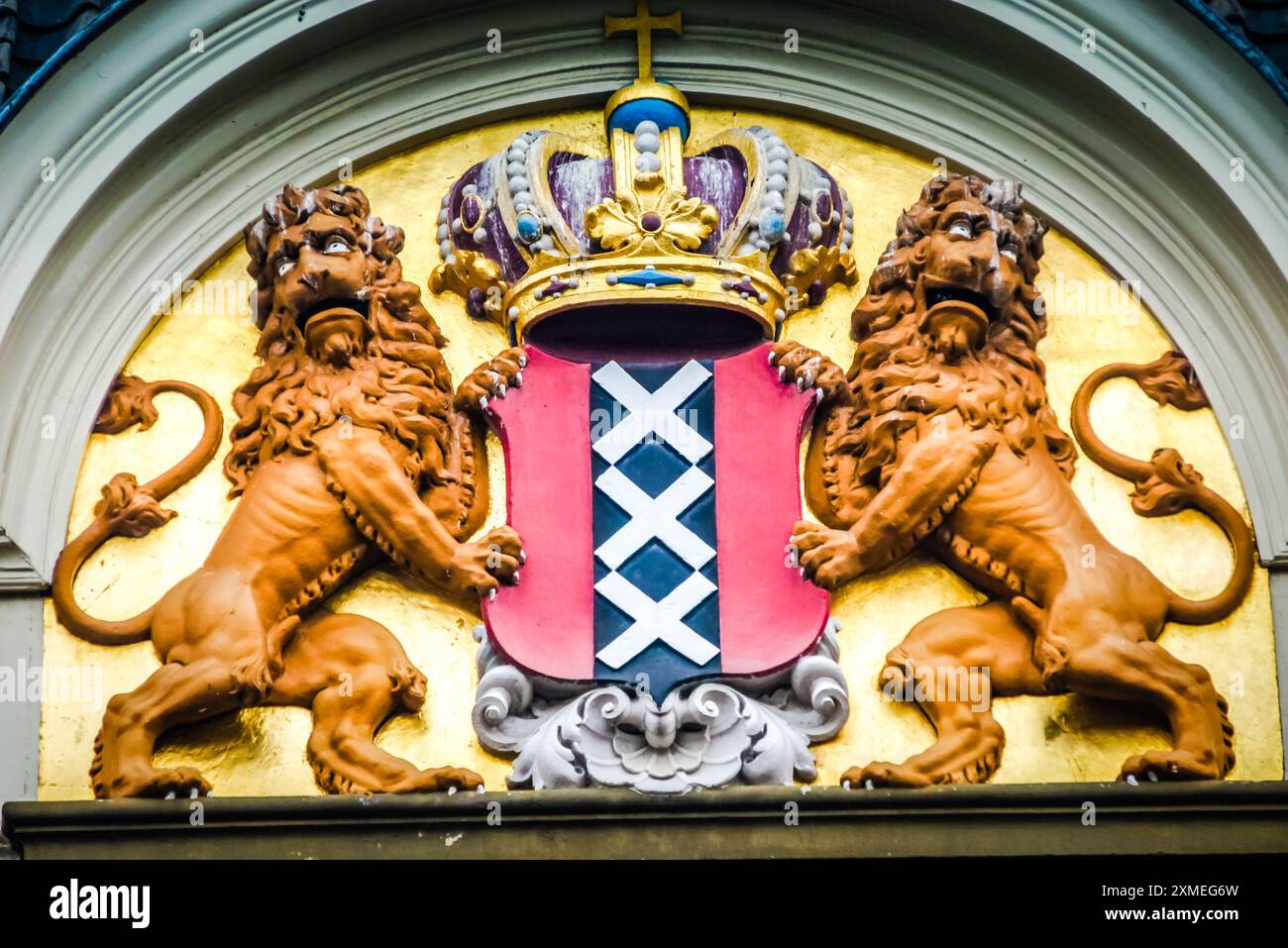 Das Amsterdamer Wappen zeigt zwei wilde Löwen, die einen zentralen roten Schild flankieren. Das Schild zeigt einen schwarzen Streifen, der mit drei goldenen Saltir aufgeladen ist Stockfoto