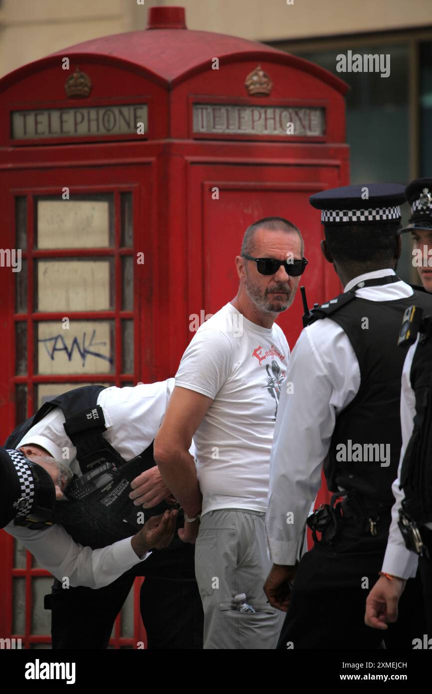 London, England, Großbritannien. Juli 2024. Polizisten verhaften einen Mann und bringen ihn aus der Gegend, da sie glaubten, dass er nach Ärger gesucht hätte, als die Parade an der Regent Street vorbeigeht. Das Thema der diesjährigen Parade lautet: „˜Gerechtigkeit und Befreiung“, die für die Trans-Rechte und in Solidarität mit Palästina, Sudan, Haiti und Kongo steht. Der sechste Jahrestag 2024 folgt einer Zunahme von Versuchen, den Menschenrechtsorganisatoren der Trans-Community zu bremsen. Dazu gehört auch die jüngste Politik der früheren konservativen Regierung zur "Gender-Ideologie", die nicht mehr in Schulen gelehrt werden soll. Anderswo ist der Stockfoto