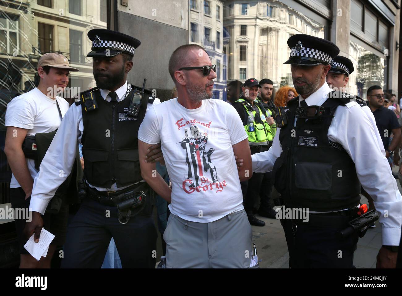 London, England, Großbritannien. Juli 2024. Polizisten verhaften einen Mann und bringen ihn aus der Gegend, da sie glaubten, dass er nach Ärger gesucht hätte, als die Parade an der Regent Street vorbeigeht. Das Thema der diesjährigen Parade lautet: „˜Gerechtigkeit und Befreiung“, die für die Trans-Rechte und in Solidarität mit Palästina, Sudan, Haiti und Kongo steht. Der sechste Jahrestag 2024 folgt einer Zunahme von Versuchen, den Menschenrechtsorganisatoren der Trans-Community zu bremsen. Dazu gehört auch die jüngste Politik der früheren konservativen Regierung zur "Gender-Ideologie", die nicht mehr in Schulen gelehrt werden soll. Anderswo ist der Stockfoto