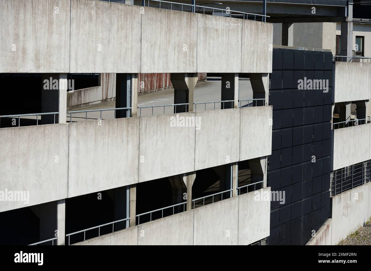 Dieses Bild zeigt eine Außenansicht eines mehrstöckigen Parkhauses. Die Betonkonstruktion zeigt das raue, industrielle Design, das typisch für den urbanen Bogen ist Stockfoto