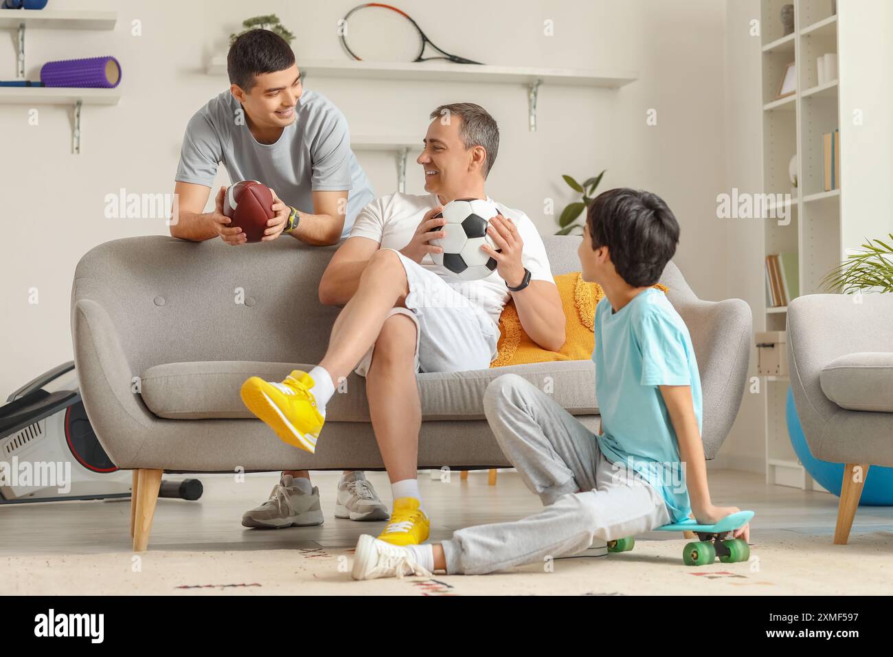 Sportlicher kleiner Junge mit Vater und Großvater zu Hause Stockfoto