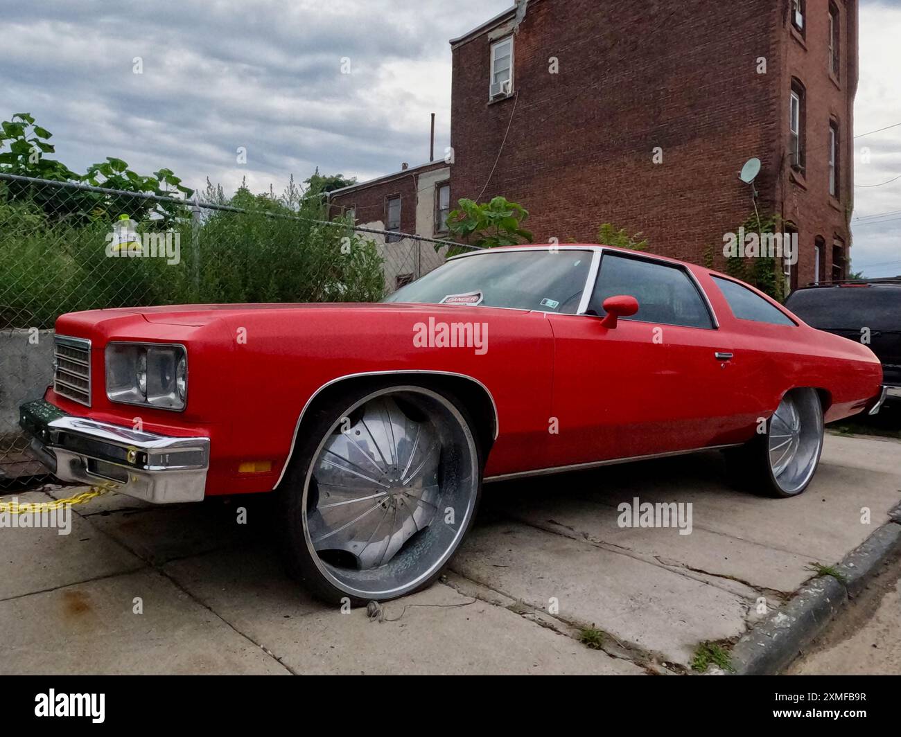 Ein modifizierter Chevrolet, der als Donk bezeichnet wird, steht auf dem Bürgersteig in North Philadelphia. Stockfoto