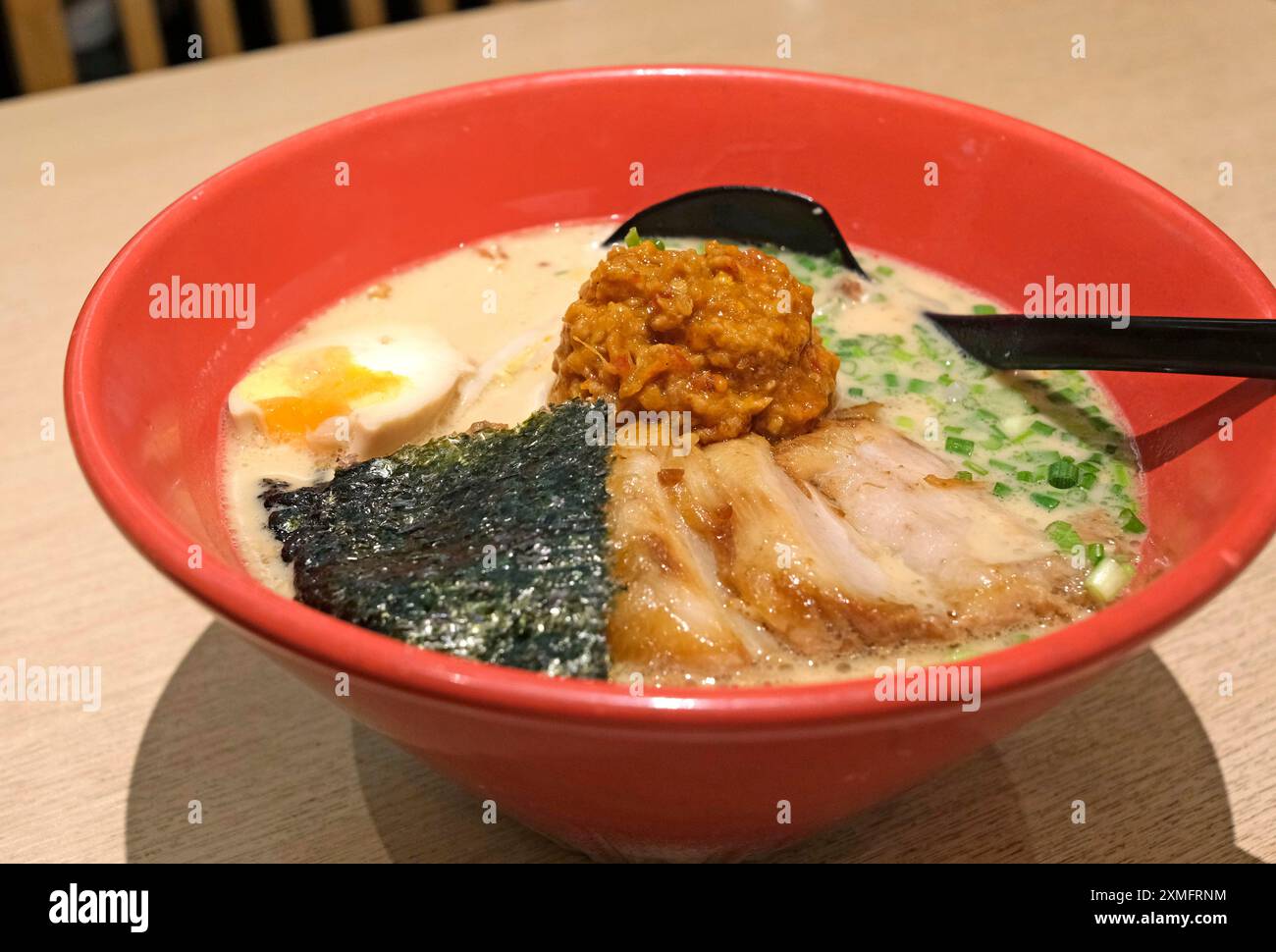 Die japanischen Ramen-Nudeln mit Schweinefleisch, Algen, Suppe in roter Schüssel Stockfoto