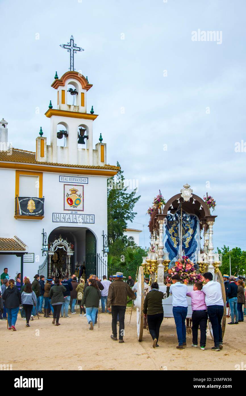 Pilger zu Pferd nähern sich durch den Sand des Doñana-Nationalparks zu ihrem Ziel im Dorf El Rocio in Almonte am Ende des Stockfoto