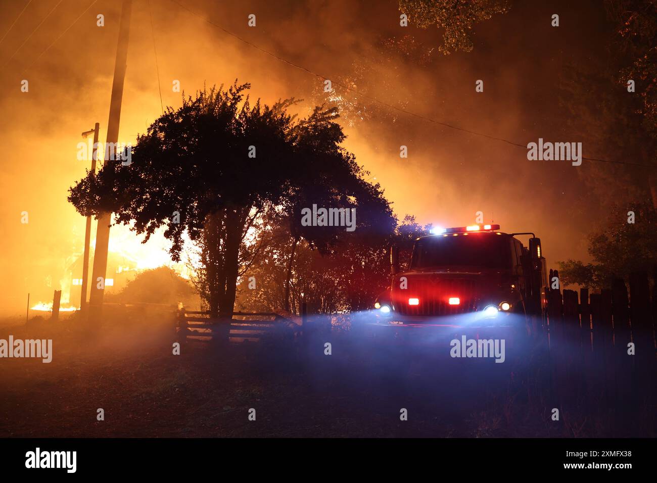 Das Foto zeigt Feuerwehrmänner, die am 26. Juli 2024 in Kalifornien, USA, gegen To Flames kämpften. Kaliforniens größtes aktives Feuer explodierte am Freitagabend, wuchs rasch unter knochentrockenen Brennstoffen an und bedrohte Tausende von Häusern, als sich die Feuerwehrleute um die Gefahr bemühten. Die Intensität und schnelle Ausbreitung des Parkfeuers veranlassten die Feuerbeamten, unwillkommene Vergleiche mit dem monströsen Lagerfeuer anzustellen, das 2018 im nahegelegenen Paradise außer Kontrolle brannte, 85 Menschen tötete und 11.000 Häuser abbrannte. Bisher wurden mehr als 130 Gebäude durch diesen Brand zerstört, und Tausende weitere sind noch immer bedroht Stockfoto