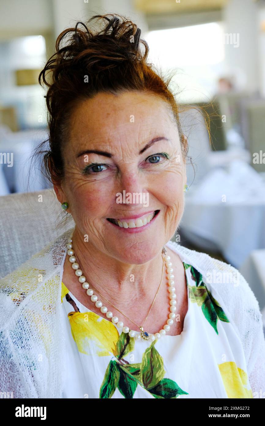 Porträt einer schönen reiferen Frau, die in die Kamera lächelt - John Gollop Stockfoto