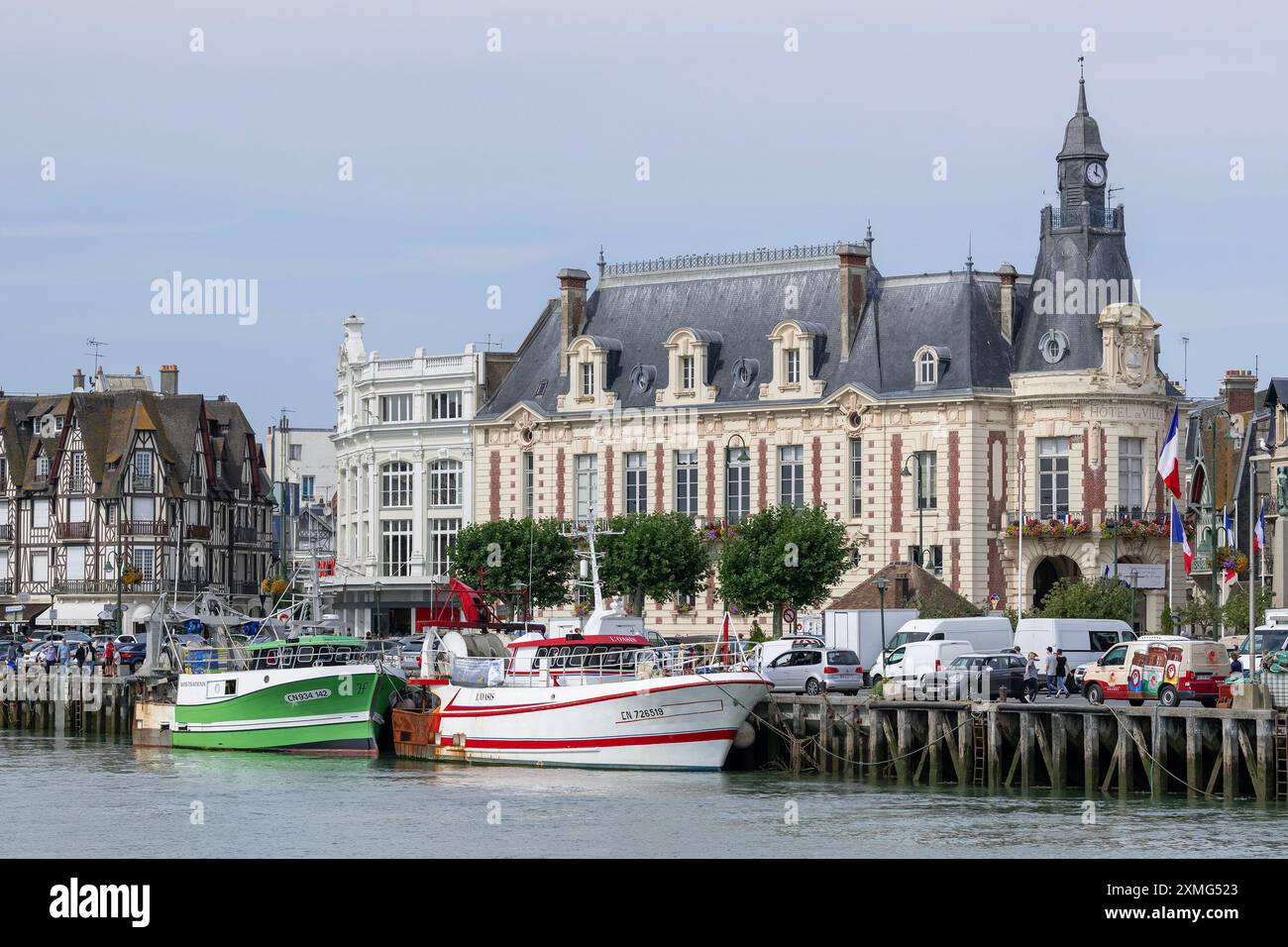Trouville-sur-Mer, Frankreich - Blick auf den Kai des Flusses Touques mit Fischerbooten und das Rathaus in der Innenstadt von Trouville. Stockfoto