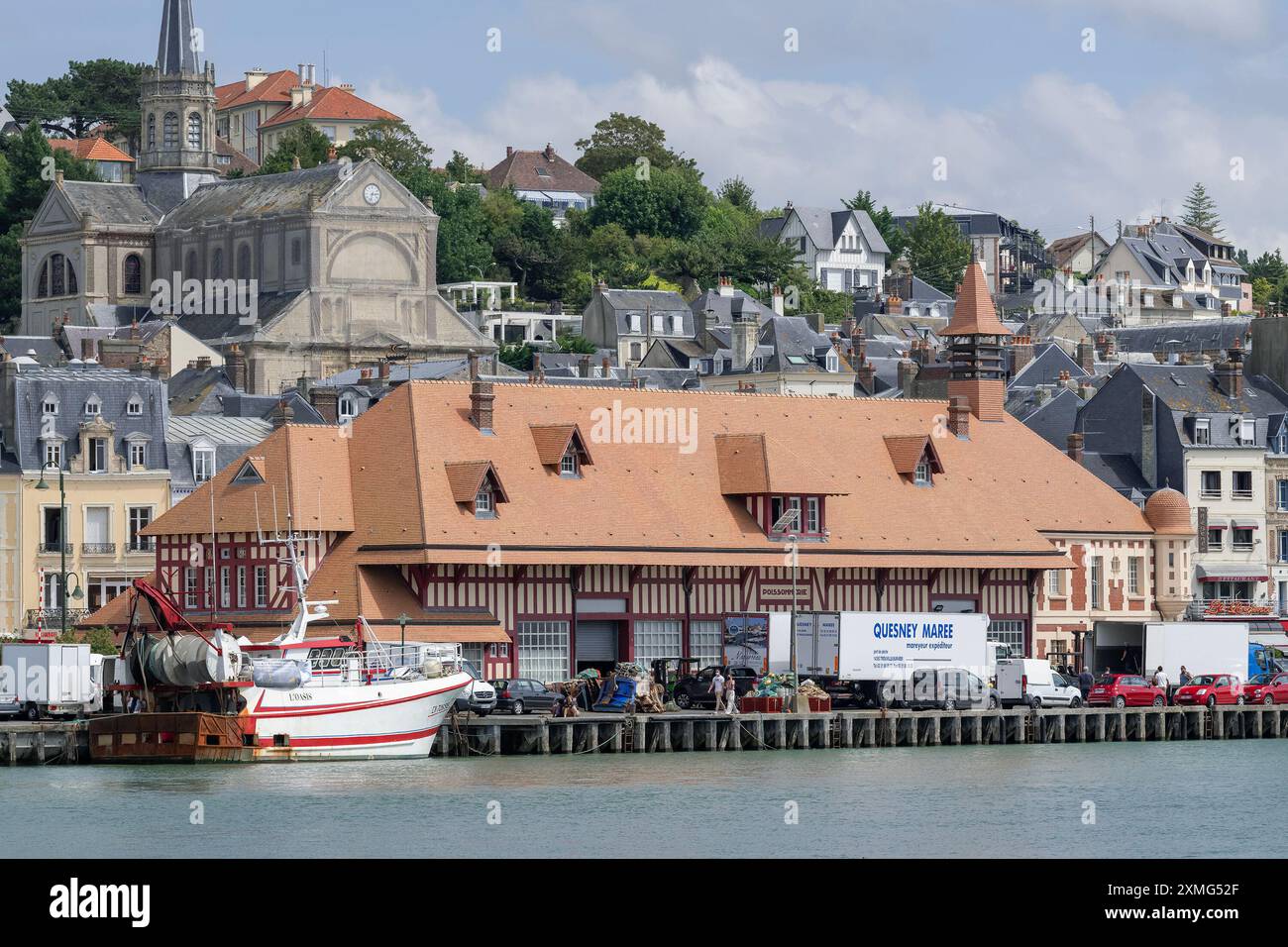 Trouville-sur-Mer, Frankreich - Blick auf den Kai des Flusses Touques mit Fischerbooten und das Rathaus in der Innenstadt von Trouville. Stockfoto