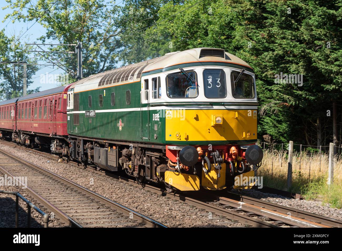 Ingatestone, Essex, Großbritannien. Juli 2024. Der Organisator UK Railtours betreibt einen klassischen dieselgeschleppten Personenzug vom Bahnhof London Fenchurch Street in die Küstenstadt Clacton-on-Sea in Essex, zunächst mit einer Lokomotive der British Rail Class 33 Nummer D6515 aus den 1960er Jahren bis nach Harwich. Eine Lokomotive der Baureihe 66 bringt den Zug nach Clacton und die Rückfahrt nach London. 98 dieselelektrische Lokomotiven der Baureihe 33 wurden zwischen 1960 und 1962 für die südliche Region der British Railways gebaut, die letzte wurde Mitte der 1990er Jahre ausgemustert Stockfoto