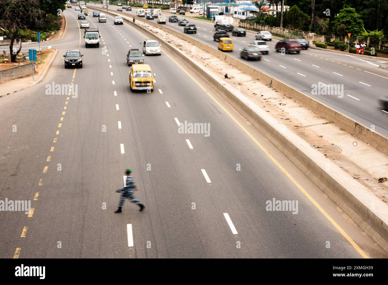 Ein Polizeibeamter überquert den Lagos Ibadan Highway, Nigeria, 27. Juli 2024. Benzin verkauft sich zu 850 Naira pro Liter. EndbadGovernace Protest auf h gesetzt Stockfoto