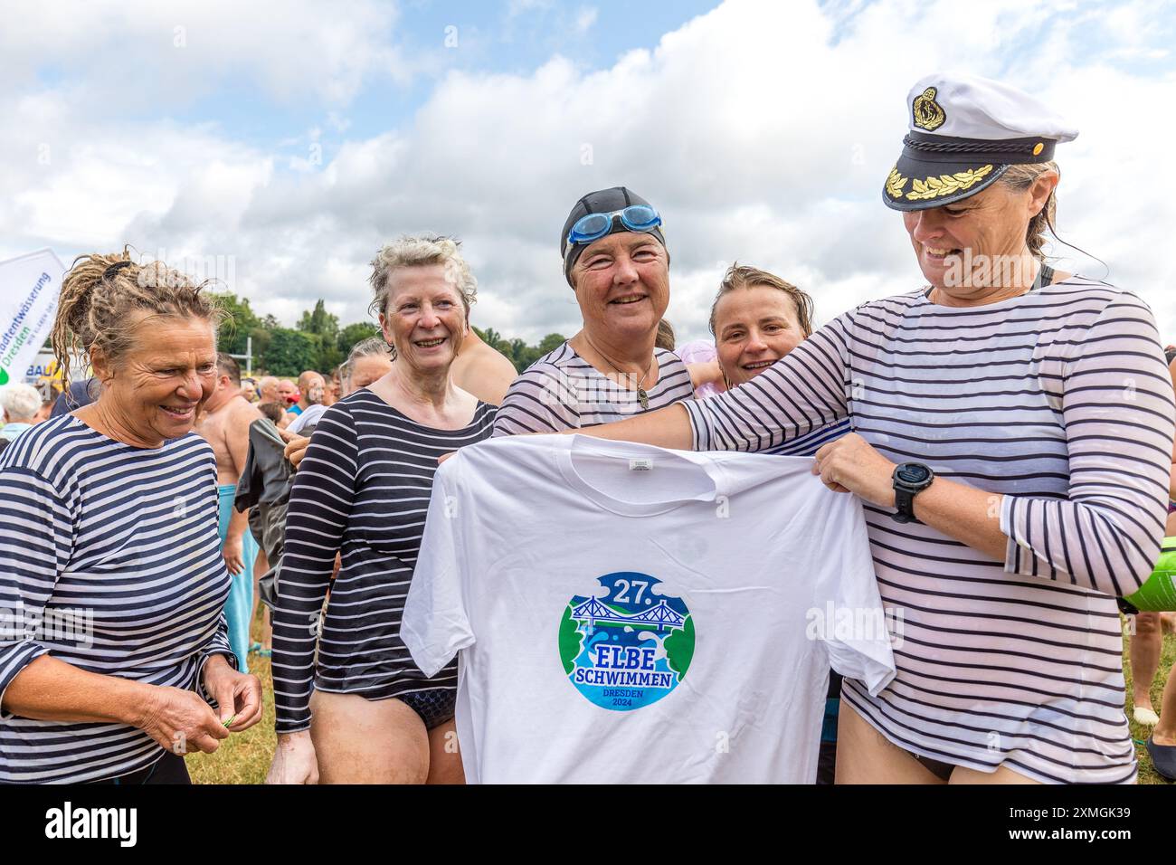 Dresden, Deutschland. Juli 2024. Cordula (l-r), Christiane, Annegret, Mandy und Gudrun aus Dresden halten ein Elb-Schwimmtrikot in den Händen. Das Elbschwimmen findet in diesem Jahr zum 27. Mal statt. Die erste Veranstaltung fand 1998 mit nur 70 Teilnehmern statt. Trotz des nicht sommerlichen Wetters machten sich zahlreiche Teilnehmer auf den rund 3,5 Kilometer langen Kurs bei Wassertemperaturen von 23 Grad und Lufttemperaturen von 18 Grad. Vermerk: Frank Hammerschmidt/dpa/Alamy Live News Stockfoto