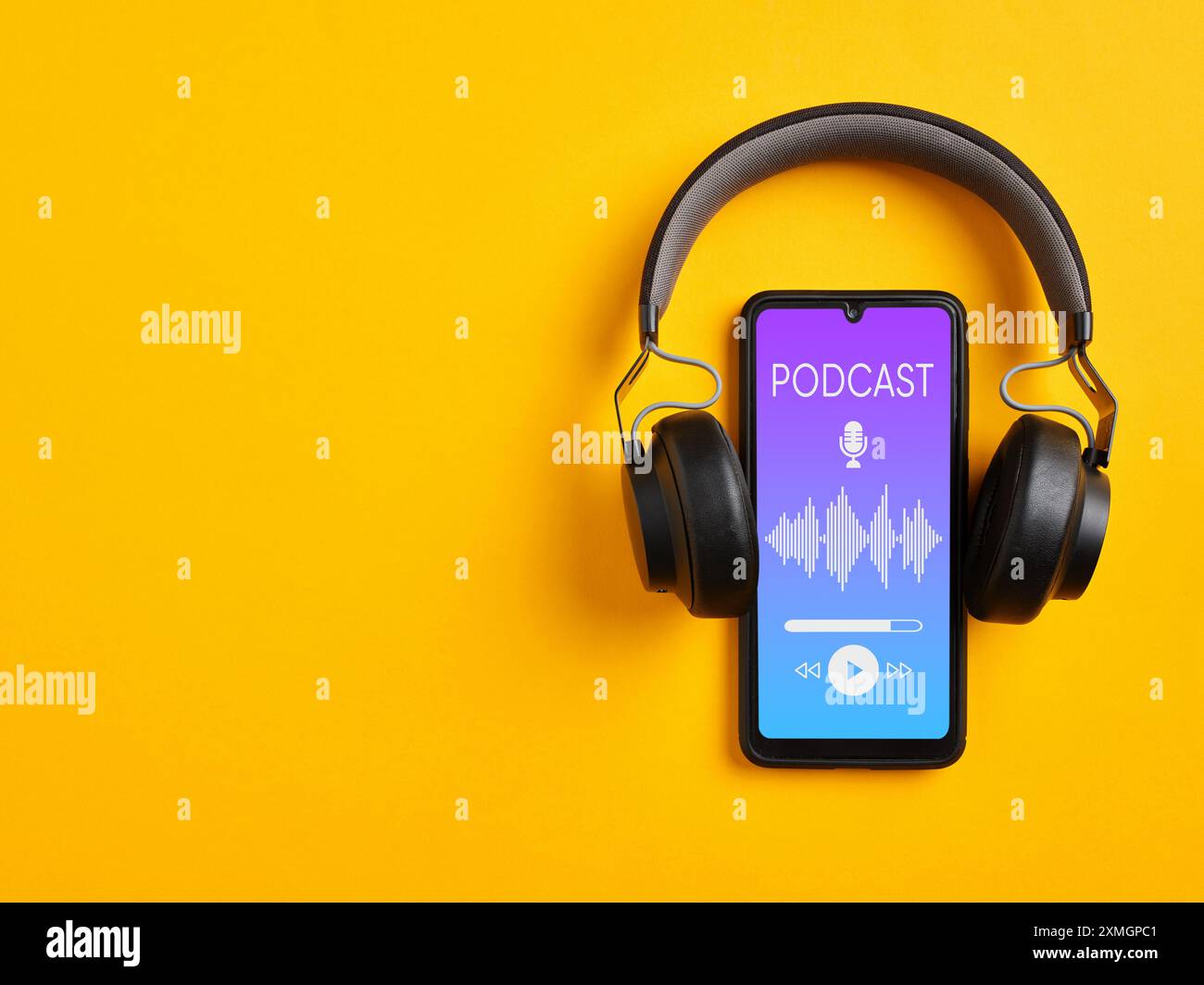 Podcast-Wiedergabe mit Smartphone-Player-App. Smartphone und kabelloser Kopfhörer mit Podcast-Bildschirm auf gelbem Hintergrund. Stockfoto