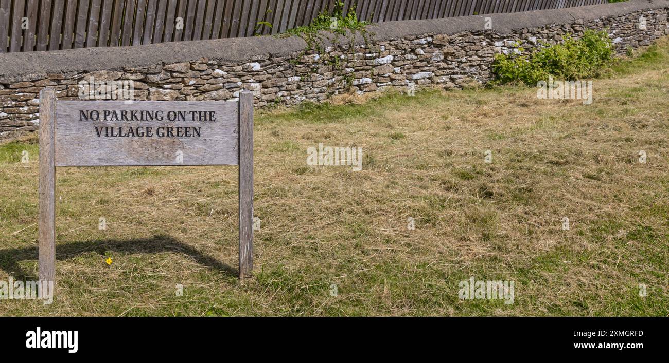 Rustikales Parken auf dem Green-Schild des Dorfes Stockfoto