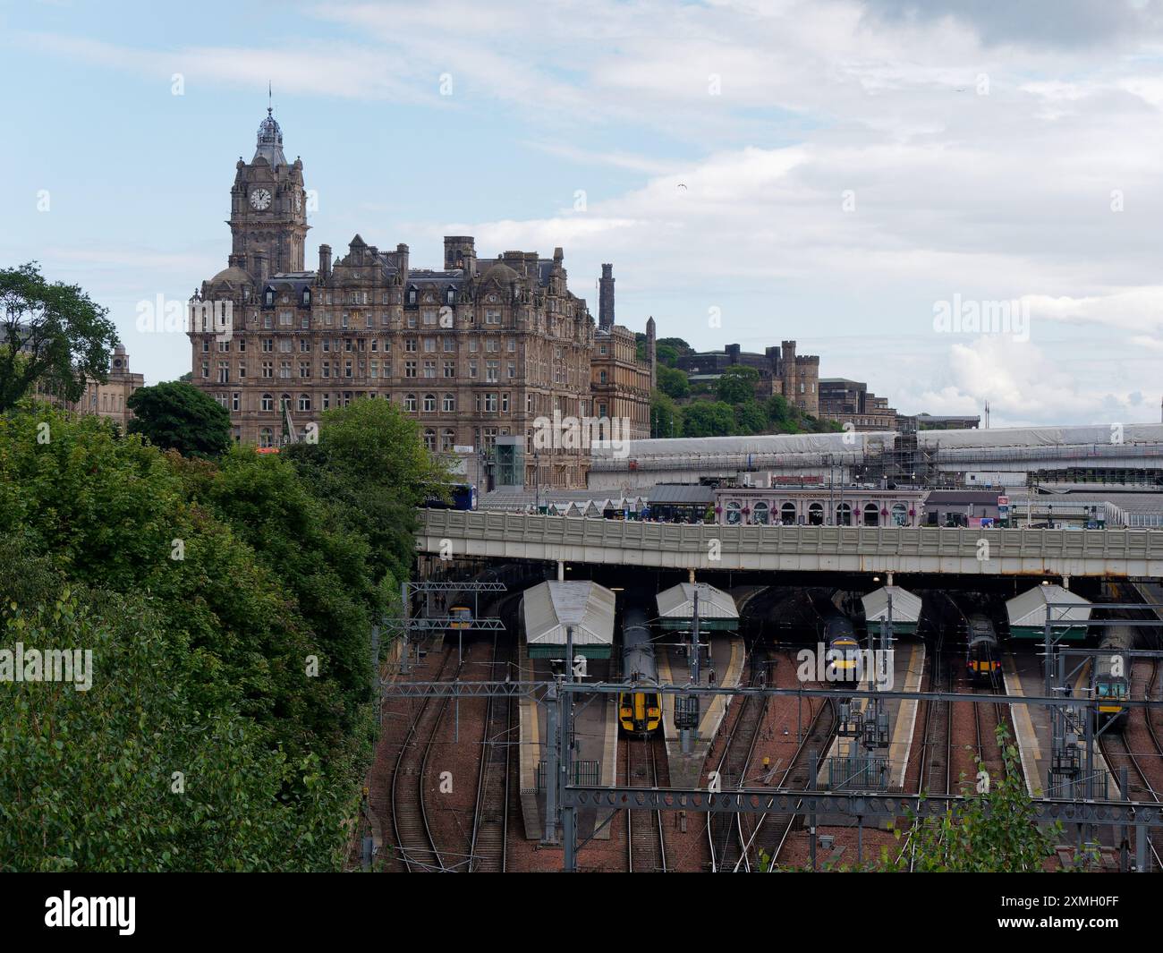 Blick hinunter auf den Bahnhof Waverley mit Balmoral Hotel Clock Tower in Edinburgh, Hauptstadt von Schottland, 27. Juli 2024 Stockfoto