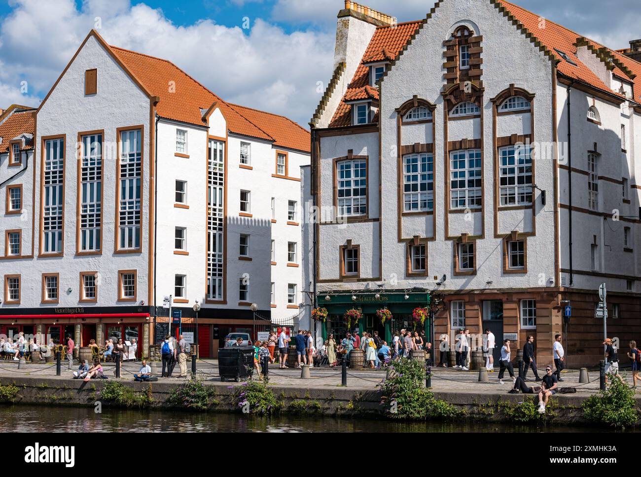 Leith, Edinburgh, Schottland, Vereinigtes Königreich, 28. Juli 2024. Wetter in Großbritannien: Da der Sommer endlich ankommt, genießen die Leute die Bars und Ausblicke in den trendigsten Wohnort der Stadt. Im Bild: Die Menschen genießen die Pubs und Cafés am Ufer. Quelle: Sally Anderson/Alamy Live News Stockfoto
