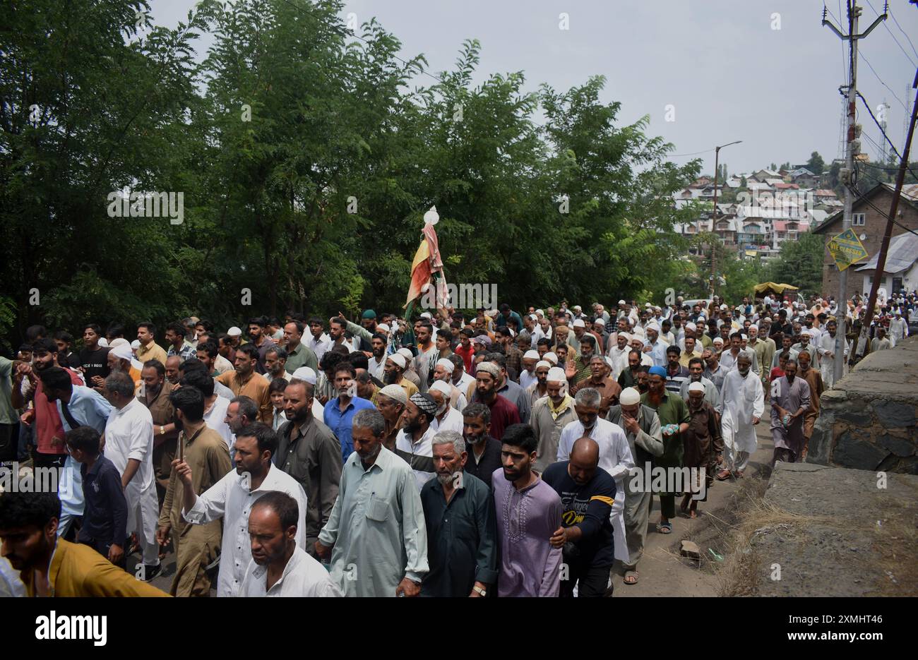 Srinagar, Kaschmir, Indien, am 28. Juli 2024: Eine Gruppe von Menschen, die barfuß die Straße entlang laufen und einen Alam halten, geht in Richtung des Schreins Scheich-ul-Alam in Kaschmir. Sie beten für Regen, um die Hitzewelle zu lindern, die die Region derzeit betrifft. Wann immer Kaschmir eine Katastrophe erlebt, reisen Bands zum Chari Sharief Schrein, der 28 Kilometer von Srinagar entfernt liegt, wo Scheich Noor DIN's (R.. A) der Schrein befindet sich. Diese Bands machen die Reise zu Fuß, barfuß, spielen traditionelle Band Pather und beten für die von der Katastrophe Betroffenen, während sie gehen. Foto: Danish Showkat/SIPA USA. Stockfoto