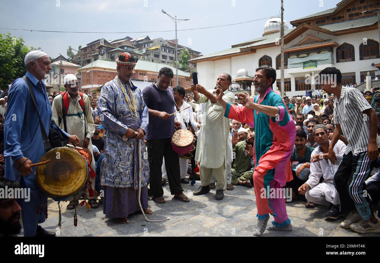 Srinagar, Kaschmir, Indien, am 28. Juli 2024: Bands, die kulturelle Aktivitäten in bunten Gewändern durchführen, können in Sheikh-ul-Alams Räumlichkeiten in Charari Sharief gesehen werden. Wann immer Kaschmir eine Katastrophe erlebt, reisen Bands zum Chari Sharief Schrein, der 28 Kilometer von Srinagar entfernt liegt, wo Scheich Noor DIN's (R.. A) der Schrein befindet sich. Diese Bands machen die Reise zu Fuß, barfuß, spielen traditionelle Band Pather und beten für die von der Katastrophe Betroffenen, während sie gehen. Foto: Danish Showkat/SIPA USA. Stockfoto