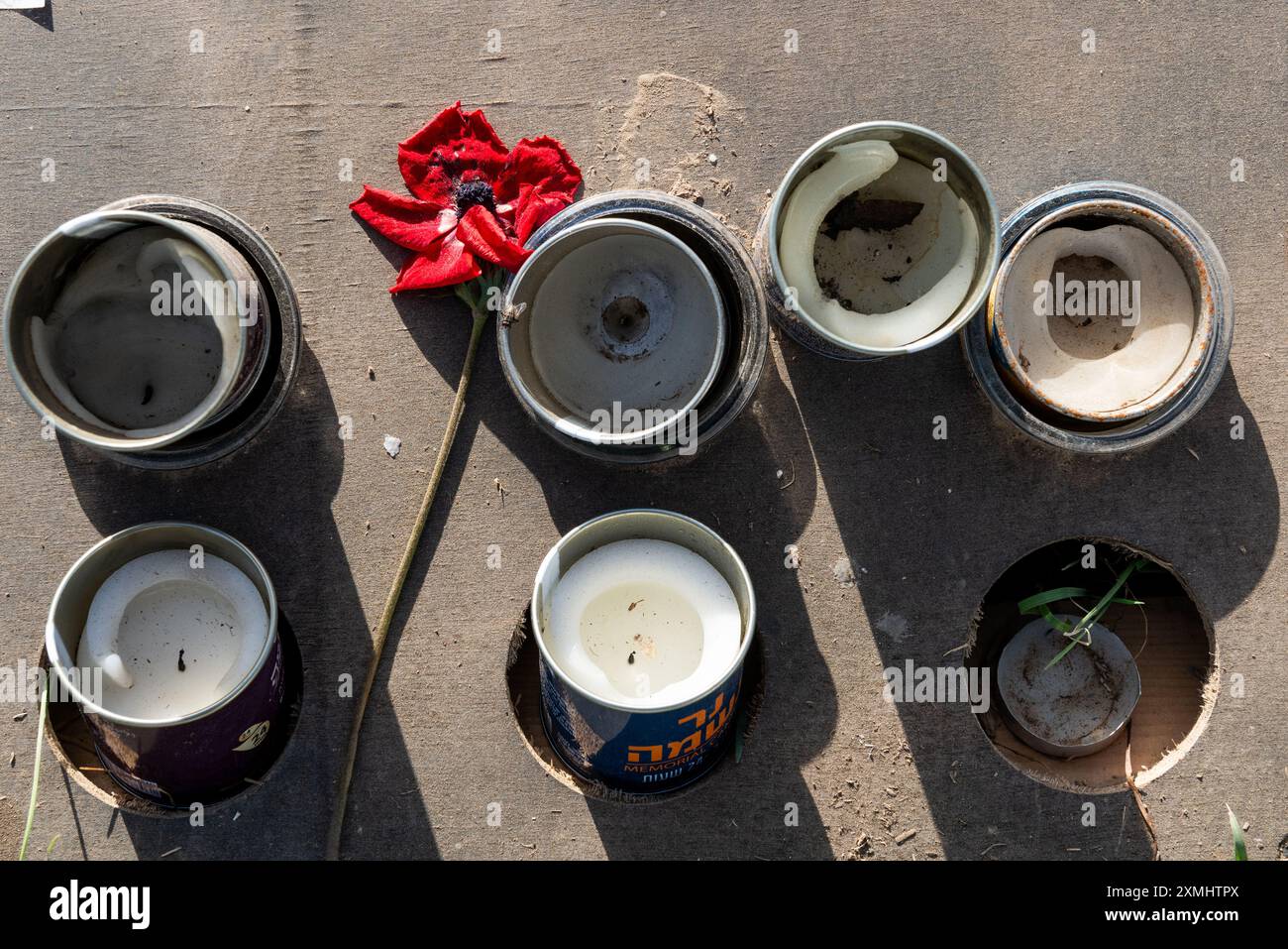 Unbeleuchtete Gedenkkerzen und eine verwelkte Blume am Ort des Nova Music Festivals im Süden Israels zu Ehren des Opfers eines Palästinensers Stockfoto